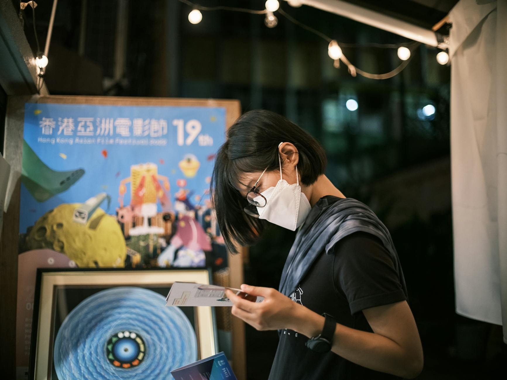 a short haired woman in black shirt wearing face mask